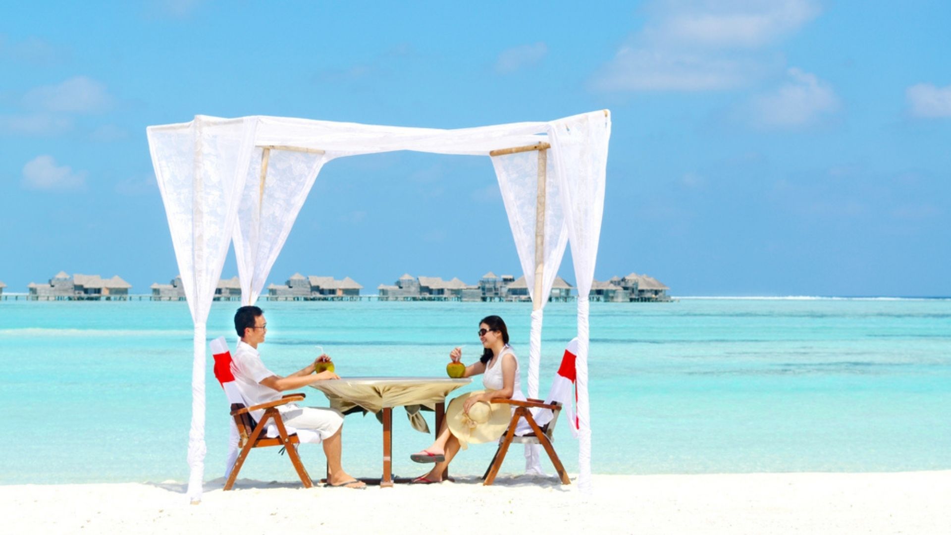 Couple enjoying romantic luxury lunch setting at tropical beach in Maldives